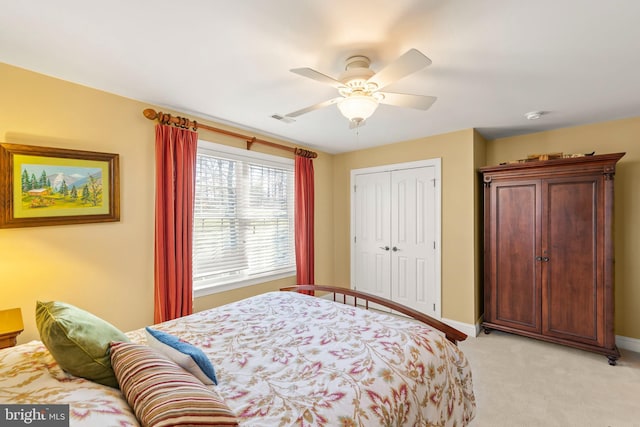 carpeted bedroom featuring ceiling fan and a closet