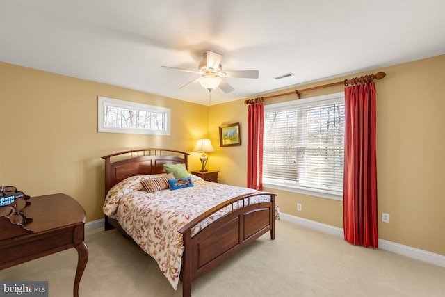 carpeted bedroom with multiple windows and ceiling fan