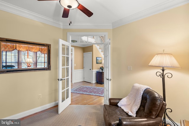 sitting room featuring ceiling fan, light wood-type flooring, ornamental molding, and french doors