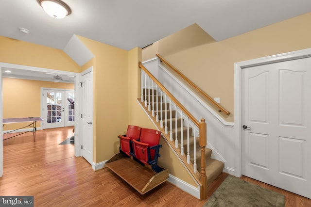 staircase featuring ceiling fan, wood-type flooring, and french doors