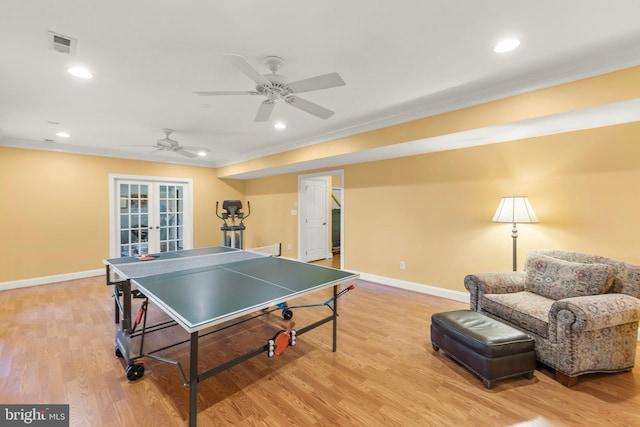 playroom with ceiling fan, french doors, ornamental molding, and light hardwood / wood-style flooring