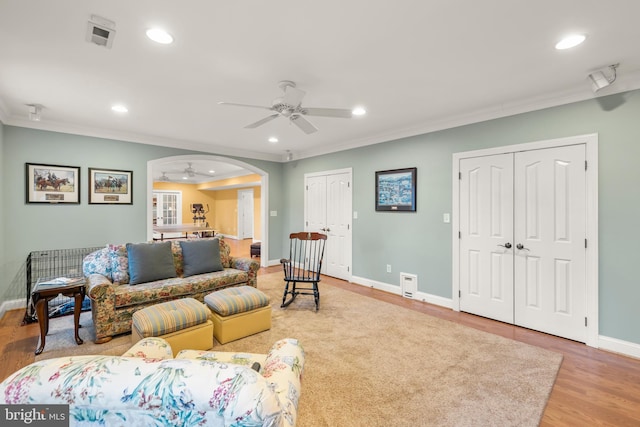 living room featuring ceiling fan, hardwood / wood-style floors, and ornamental molding