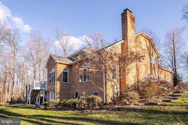 view of side of property with a yard and a deck