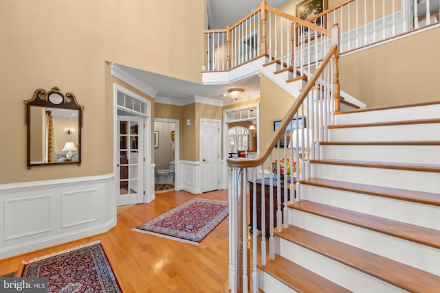 foyer entrance with crown molding, a high ceiling, and hardwood / wood-style flooring