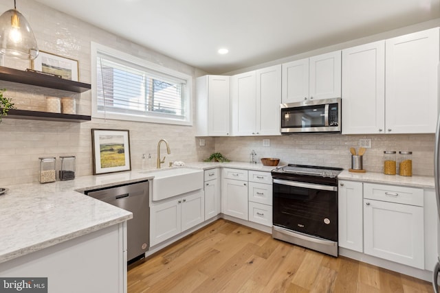 kitchen with pendant lighting, white cabinets, and stainless steel appliances