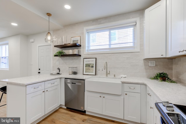 kitchen with stainless steel dishwasher, white cabinetry, sink, and kitchen peninsula