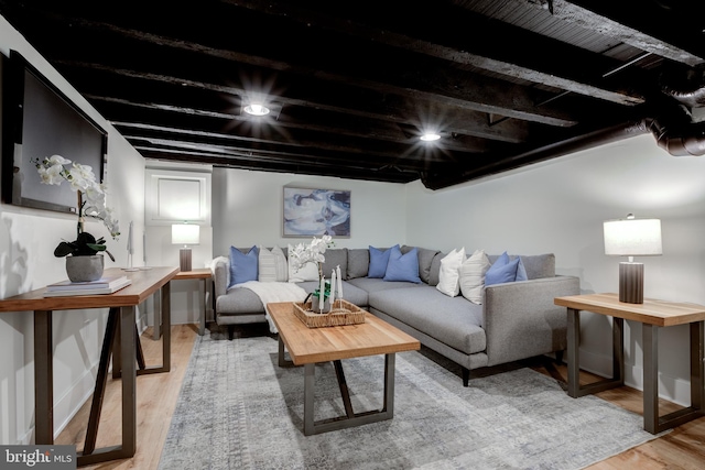 living room featuring beam ceiling and light hardwood / wood-style flooring