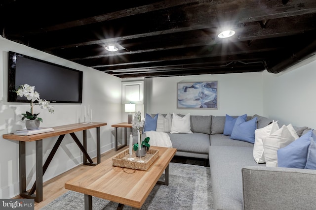 living room featuring beamed ceiling and hardwood / wood-style flooring