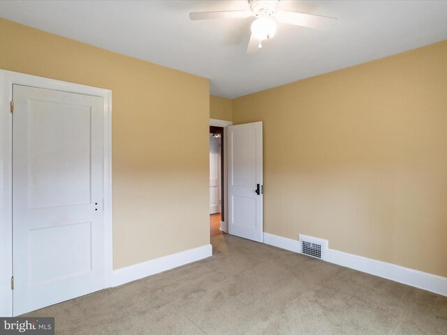 unfurnished bedroom with light carpet, a closet, and ceiling fan