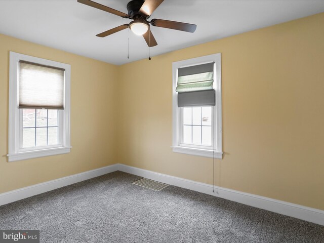 carpeted empty room featuring ceiling fan and a healthy amount of sunlight