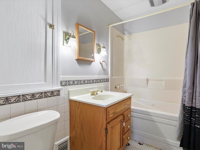 full bathroom with shower / tub combo, vanity, tile walls, tile patterned flooring, and toilet