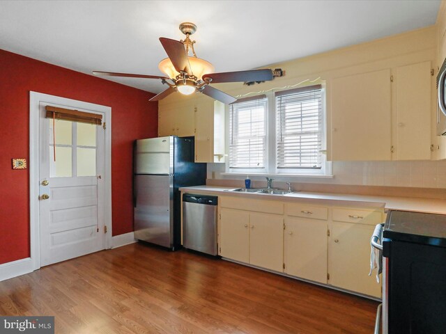 kitchen with ceiling fan, sink, stainless steel appliances, and light hardwood / wood-style flooring