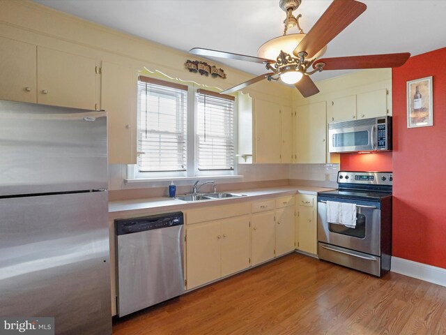 kitchen with ceiling fan, sink, stainless steel appliances, and light wood-type flooring