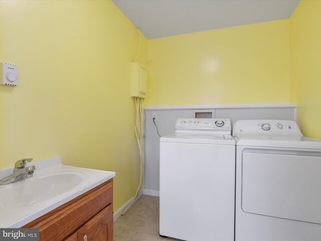 clothes washing area with washer and dryer, sink, and light carpet