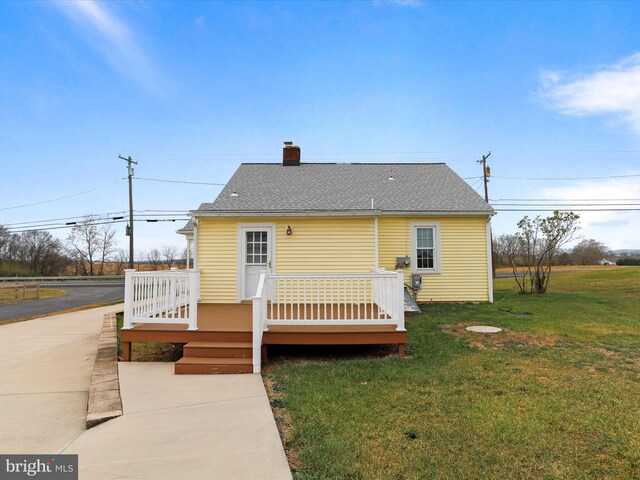 back of house with a deck and a yard