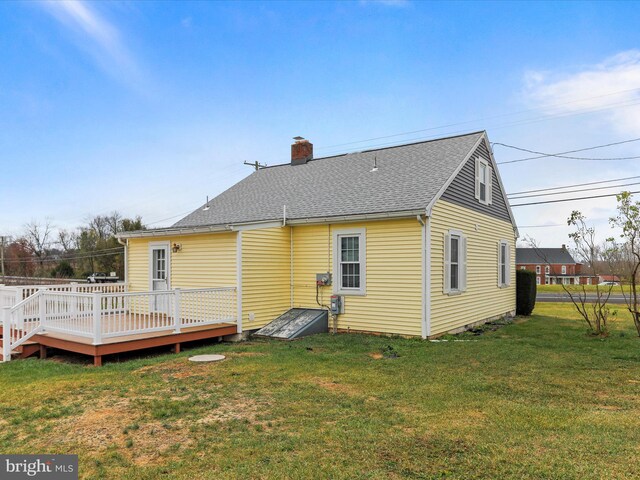 rear view of property featuring a lawn and a wooden deck