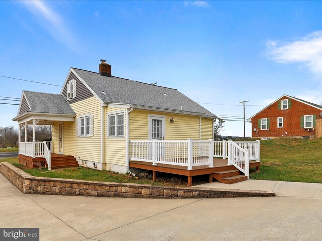 rear view of house featuring a yard and a wooden deck