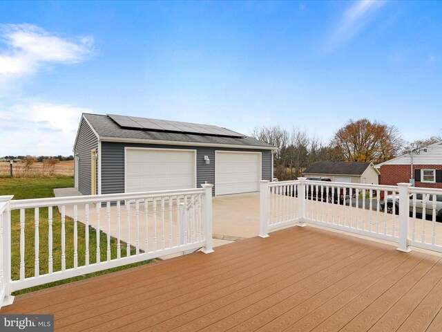 deck featuring an outbuilding, a yard, and a garage