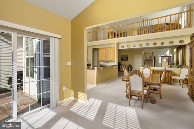 dining room featuring light carpet and high vaulted ceiling