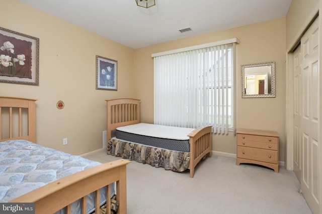 bedroom with light carpet and a closet