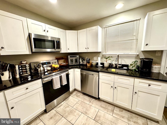 kitchen featuring white cabinets, appliances with stainless steel finishes, and sink