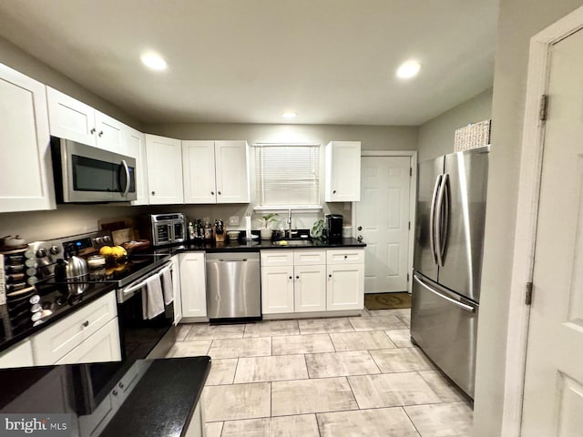 kitchen with sink, white cabinets, and appliances with stainless steel finishes