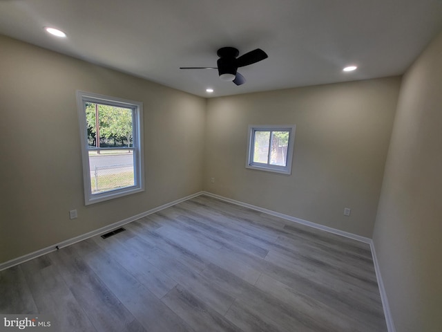 empty room with ceiling fan and light hardwood / wood-style floors