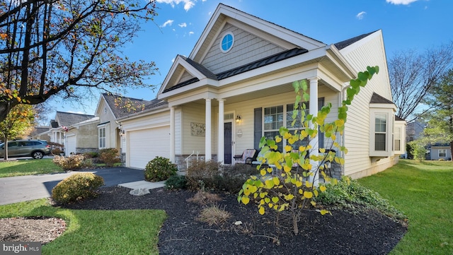 view of front facade with a garage, a porch, and a front lawn