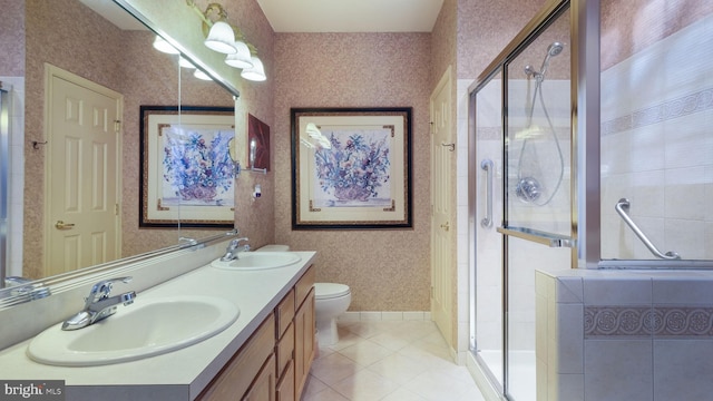 bathroom featuring vanity, a shower with door, tile patterned flooring, and toilet