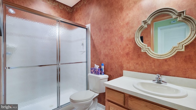 bathroom featuring walk in shower, vanity, and toilet