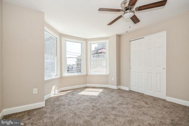 unfurnished bedroom featuring a closet, carpet, and ceiling fan