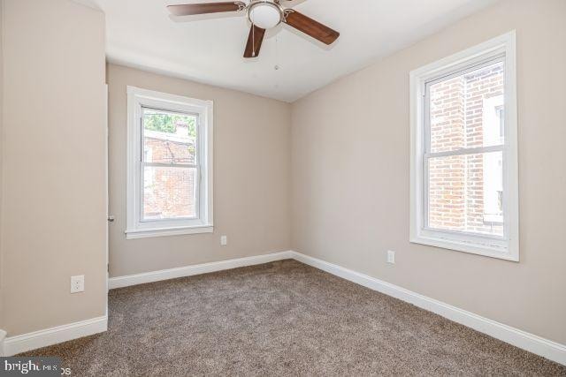 empty room with ceiling fan and carpet floors