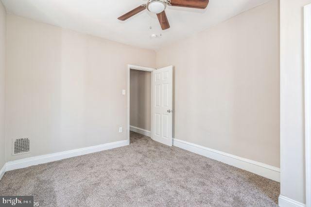 unfurnished room with ceiling fan and light colored carpet