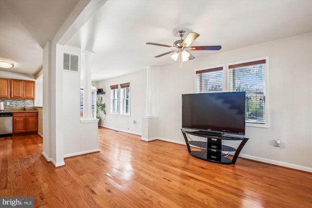 living room featuring light wood-type flooring, decorative columns, plenty of natural light, and ceiling fan