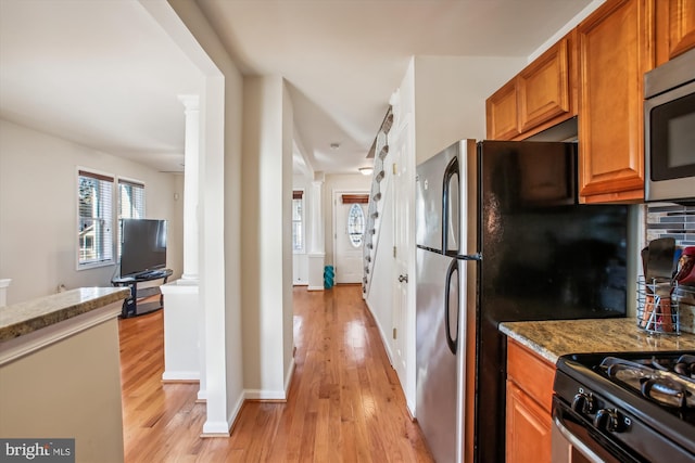 kitchen with decorative backsplash, light stone counters, and light hardwood / wood-style floors