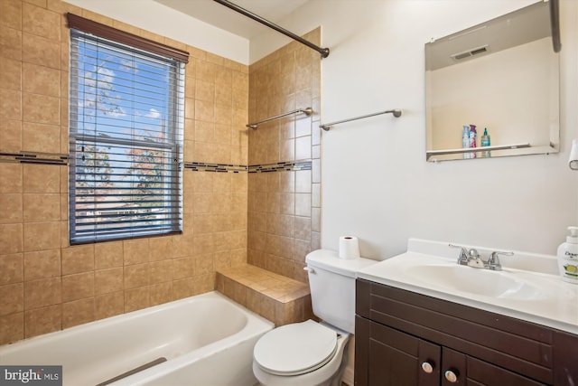 full bathroom with vanity, toilet, and tiled shower / bath combo