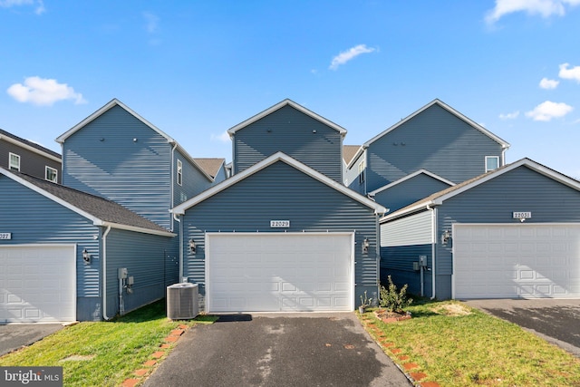 front of property featuring a garage and cooling unit