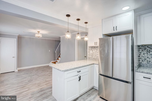 kitchen with white cabinets, decorative backsplash, kitchen peninsula, and stainless steel refrigerator