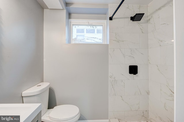 bathroom with vanity, toilet, and tiled shower