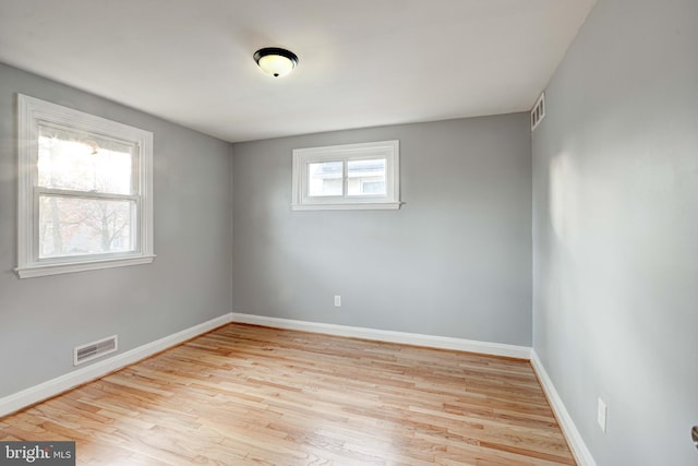 spare room featuring a healthy amount of sunlight and light hardwood / wood-style flooring