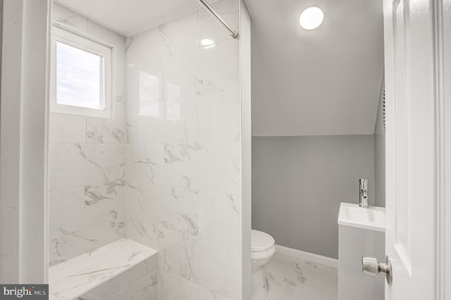 bathroom featuring tiled shower, vanity, and toilet