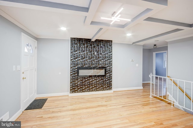 interior space featuring a stone fireplace, ornamental molding, and hardwood / wood-style flooring