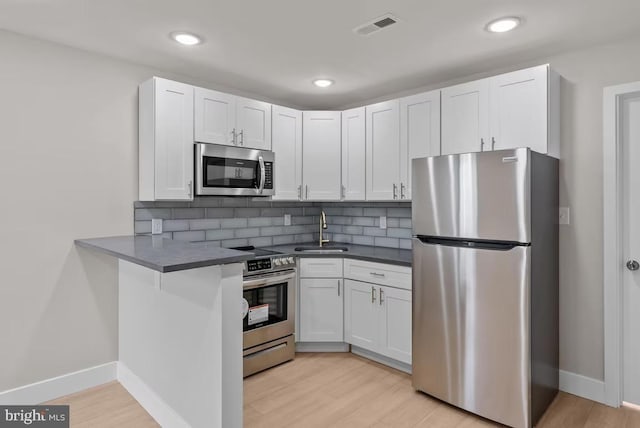 910 N Markoe St, Philadelphia, PA 19131 - kitchen with appliances with stainless steel finishes, a sink, dark countertops, decorative backsplash, and baseboards