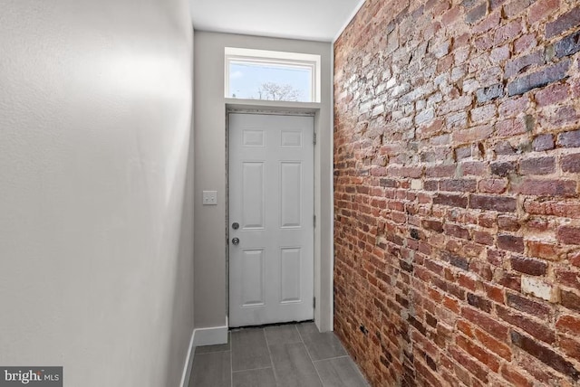 entryway featuring brick wall