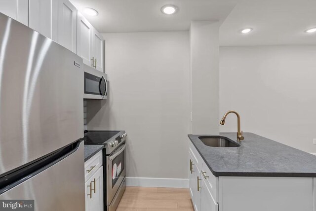 910 N Markoe St, Philadelphia, PA 19131 - kitchen featuring stainless steel appliances, a sink, white cabinets, baseboards, and recessed lighting