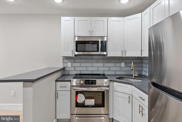 kitchen with sink, white cabinetry, and stainless steel appliances