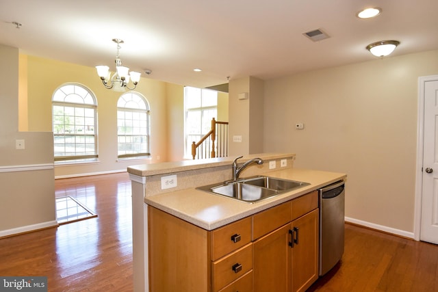 kitchen with decorative light fixtures, stainless steel dishwasher, hardwood / wood-style flooring, and sink