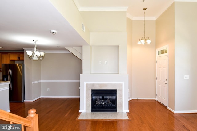 unfurnished living room with a high end fireplace, wood-type flooring, and ornamental molding