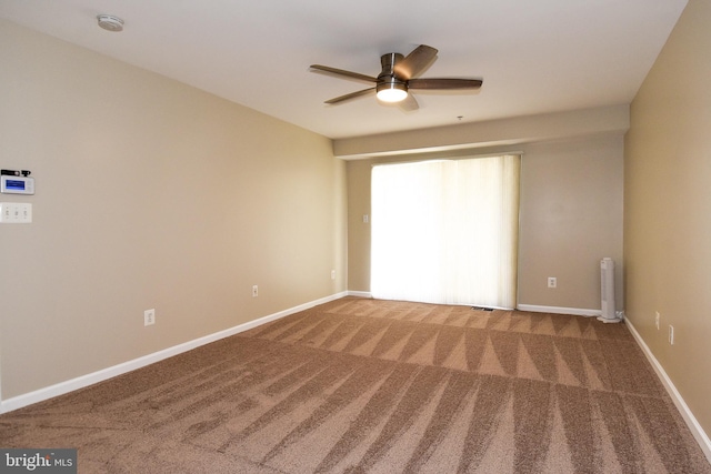 unfurnished room featuring ceiling fan and carpet