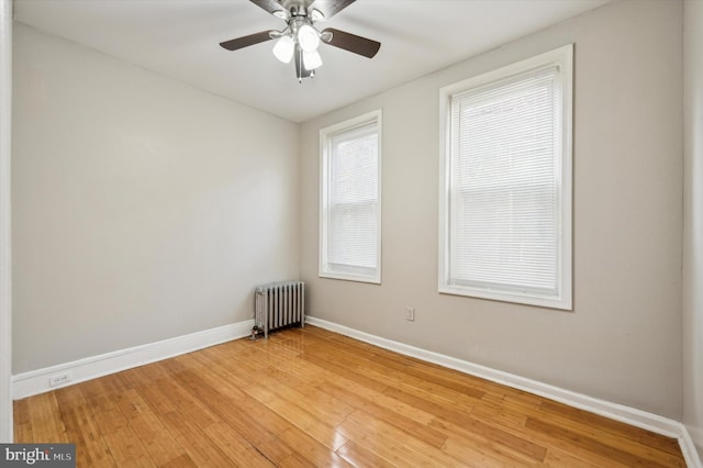 unfurnished room with radiator heating unit, ceiling fan, and hardwood / wood-style floors